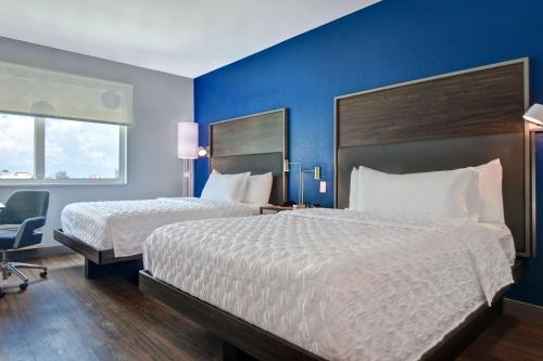 a hotel room with two beds and a chair at Tru By Hilton St. Petersburg Downtown Central Ave in St Petersburg