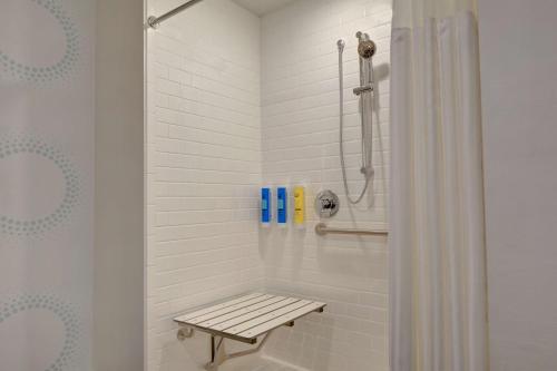a shower with a bench in a bathroom at Tru By Hilton St. Petersburg Downtown Central Ave in St Petersburg