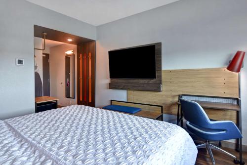 a hotel room with a bed and a flat screen tv at Tru By Hilton St. Petersburg Downtown Central Ave in St Petersburg