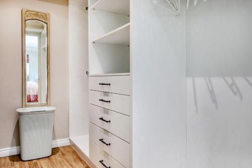 a closet with white drawers and a mirror at Solar Power French Country Cottage on Table Mountain in Cape Town