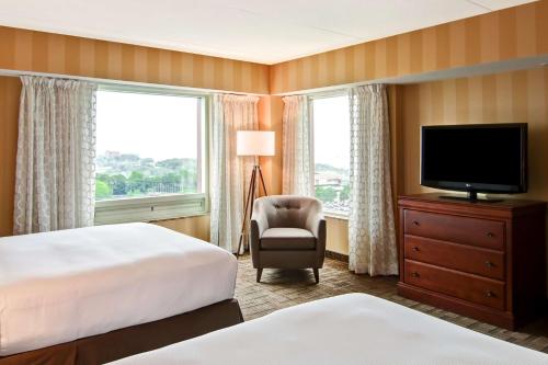 una camera d'albergo con letto, TV e sedia di DoubleTree Fallsview Resort & Spa by Hilton - Niagara Falls a Niagara Falls