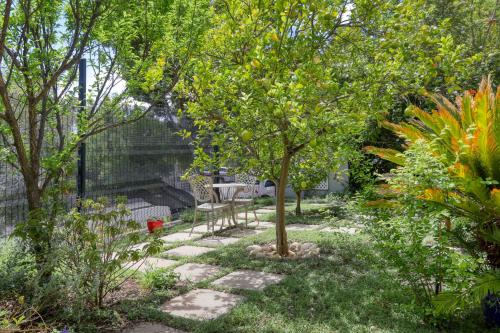 a garden with a table and chairs under a tree at Solar Power French Country Cottage on Table Mountain in Cape Town