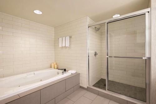 a white bathroom with a tub and a shower at Embassy Suites by Hilton Atlanta at Centennial Olympic Park in Atlanta