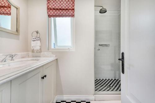 a white bathroom with a sink and a shower at Solar Power French Country Cottage on Table Mountain in Cape Town