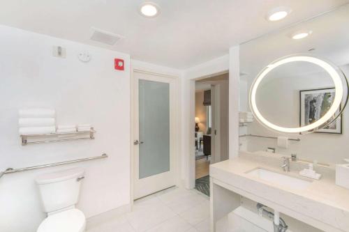 a bathroom with a toilet and a sink and a mirror at Embassy Suites by Hilton Raleigh Durham Airport Brier Creek in Raleigh