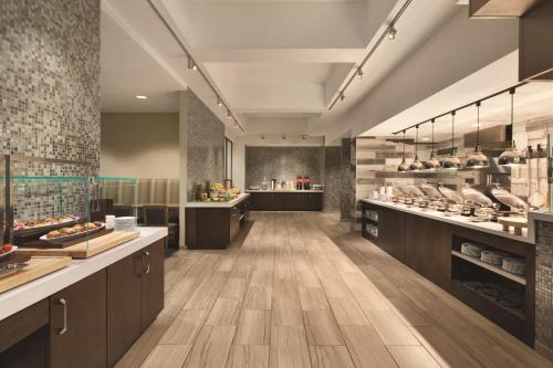 a large kitchen with wooden floors and aasteryasteryasteryasteryasteryasteryasteryastery at Embassy Suites San Antonio Brooks City Base Hotel & Spa in San Antonio