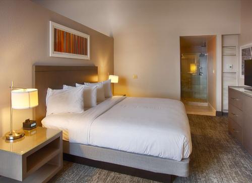a bedroom with a large white bed and a bathroom at DoubleTree by Hilton Denver/Westminister in Westminster