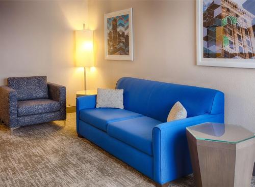 a living room with a blue couch and a chair at DoubleTree by Hilton Denver/Westminister in Westminster