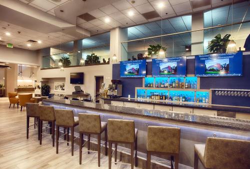 a bar in a restaurant with chairs and televisions at DoubleTree by Hilton Denver/Westminister in Westminster