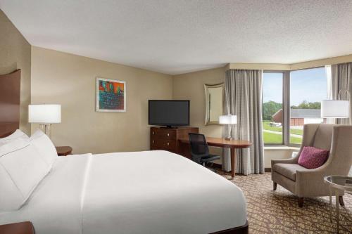 a hotel room with a bed and a desk and a tv at DoubleTree by Hilton Jackson in Jackson