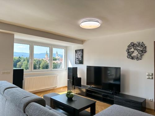 a living room with a couch and a flat screen tv at LUX residence, A/C, VIP parking, city view in Banská Bystrica