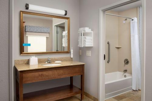 W łazience znajduje się umywalka, lustro i wanna. w obiekcie Hampton Inn & Suites Holly Springs w mieście Holly Springs