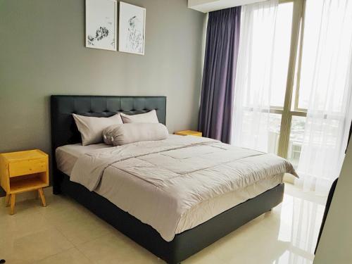 een slaapkamer met een groot bed en een raam bij Condo private Lift in Jakarta
