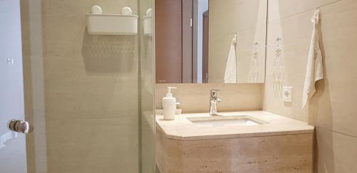 een badkamer met een wastafel en een douche met een spiegel bij Condo private Lift in Jakarta
