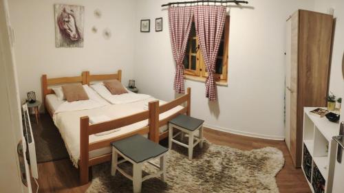 ein Schlafzimmer mit einem Bett und zwei Stühlen darin in der Unterkunft Fruška house in Bešenovački Prnjavor