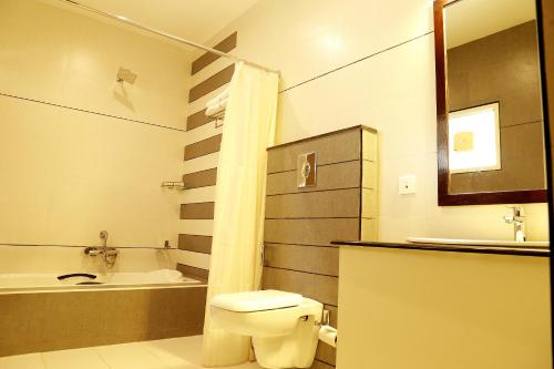 a bathroom with a toilet and a sink and a tub at Rydges Inn in Kottakkal