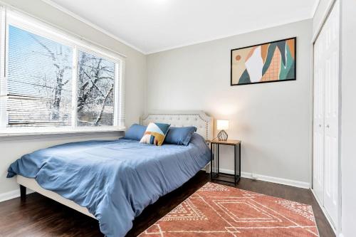 a bedroom with a bed and a large window at Vintage NYC Style & Pet Friendly Home in Oak Park