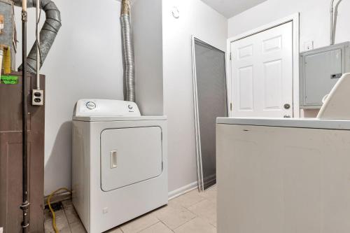 a white laundry room with a washer and dryer at Vintage NYC Style & Pet Friendly Home in Oak Park