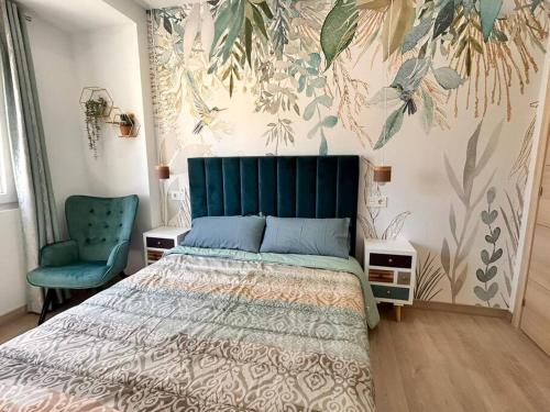 um quarto com uma cama e uma cadeira azul em LUJO: Proyector, Maquina Arcade, Wifi y Patinetes em Oviedo