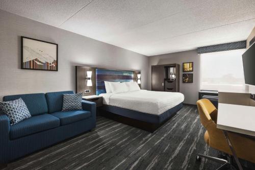 Habitación de hotel con cama y sofá en Hampton Inn Chicago-O'Hare International Airport, en Schiller Park