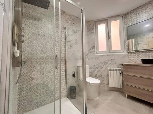 uma casa de banho com uma cabina de duche em vidro e um WC. em LUJO: Proyector, Maquina Arcade, Wifi y Patinetes em Oviedo