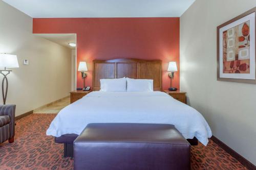 a hotel room with a large bed and a chair at Hampton Inn Owings Mills in Owings Mills