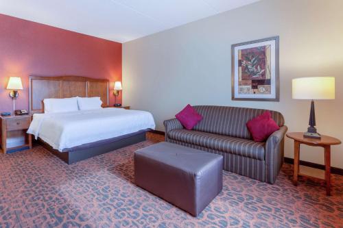 a hotel room with a bed and a couch at Hampton Inn Owings Mills in Owings Mills