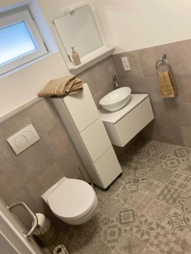 a bathroom with a white toilet and a sink at Sun&Fun Vendégház in Balatonakarattya