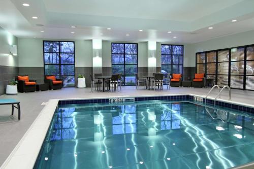 a pool in a hotel lobby with tables and chairs at Hampton Inn & Suites Columbus/University Area in Columbus