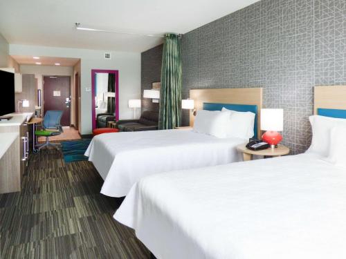 um quarto de hotel com duas camas e uma sala de estar em Home2 Suites By Hilton Pensacola I-10 Pine Forest Road em Pensacola