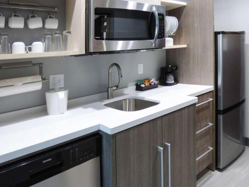 a kitchen with a sink and a refrigerator at Home2 Suites By Hilton Pensacola I-10 Pine Forest in Pensacola
