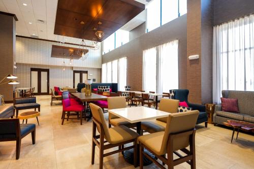 a dining room with tables and chairs and windows at Hampton Inn & Suites Aurora South, Co in Aurora