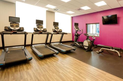 a gym with cardio machines and a pink wall at Hampton Inn & Suites Aurora South, Co in Aurora