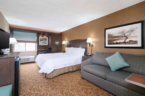 a hotel room with a bed and a couch at Hampton Inn Downingtown/Exton in Exton