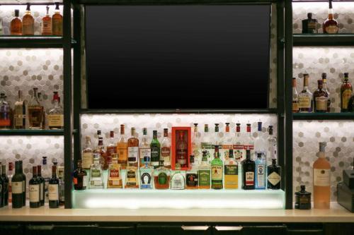 a shelf filled with lots of bottles of alcohol at Hilton Garden Inn Melville in Plainview