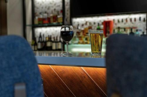 a glass of wine sitting next to a bar at Hilton Garden Inn Melville in Plainview