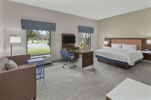 a hotel room with a bed and a desk and chair at Hampton Inn & Suites Macon I-75 North in Macon