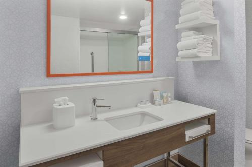 a bathroom with a sink and a mirror and towels at Hampton Inn & Suites Macon I-75 North in Macon