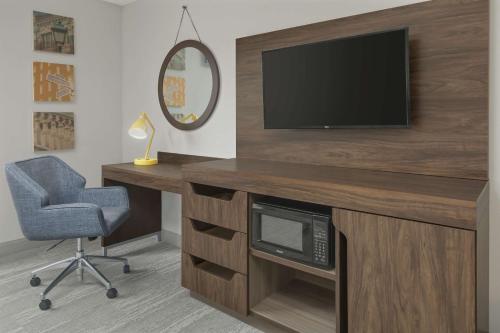 a room with a desk with a television and a chair at Hampton Inn & Suites Macon I-75 North in Macon