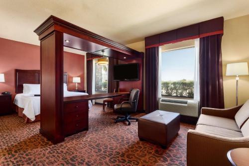 a hotel room with a bed and a desk and a window at Hampton Inn & Suites Mission in Mission