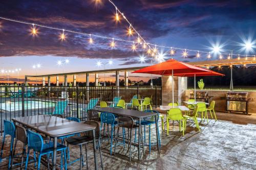 une terrasse avec des tables et des chaises ainsi qu'une piscine dans l'établissement Home2 Suites By Hilton Batesville, à Batesville