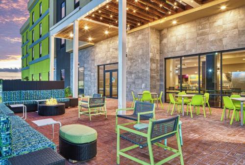eine Terrasse mit Tischen und Stühlen in einem Gebäude in der Unterkunft Home2 Suites By Hilton Batesville in Batesville
