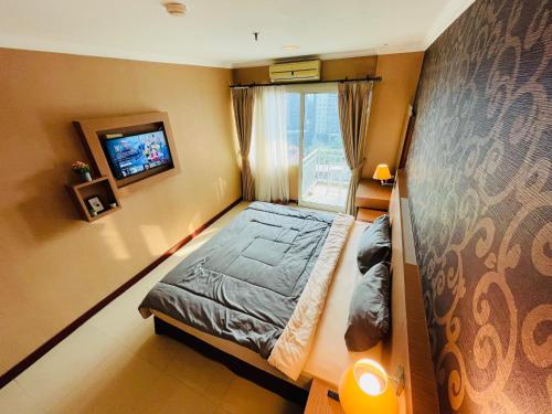 um pequeno quarto com uma cama e uma janela em Pretty Room Studio Apartment at Galeri Ciumbuleuit 1st Tower em Bandung