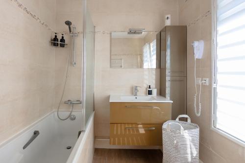 La salle de bains est pourvue d'un lavabo et d'une douche. dans l'établissement Maison proche Paris vue la Tour Eiffel, à Arcueil