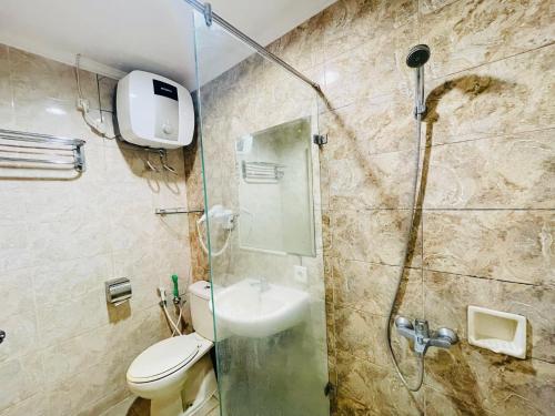 uma casa de banho com um chuveiro, um WC e um lavatório. em Pretty Room Studio Apartment at Galeri Ciumbuleuit 1st Tower em Bandung
