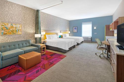 a hotel room with a bed and a couch at Home2 Suites By Hilton Batesville in Batesville