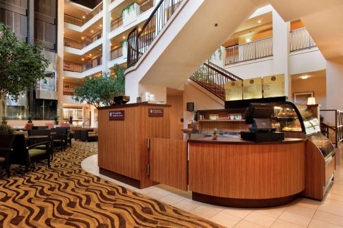 a lobby of a hotel with a restaurant with a counter at Hilton Stockton in Stockton
