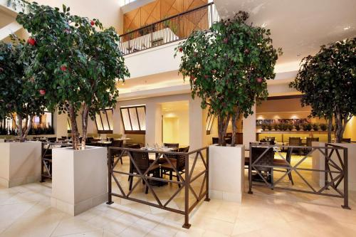 a restaurant with tables and chairs and trees at Hilton Stockton in Stockton