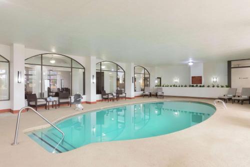una piscina in una camera d'albergo con sedie e tavoli di Embassy Suites by Hilton Tulsa I-44 a Tulsa