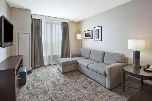 a living room with a couch and a television at Embassy Suites Columbus - Airport in Columbus